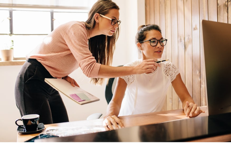 Mujeres tomando nota frente a un monitor